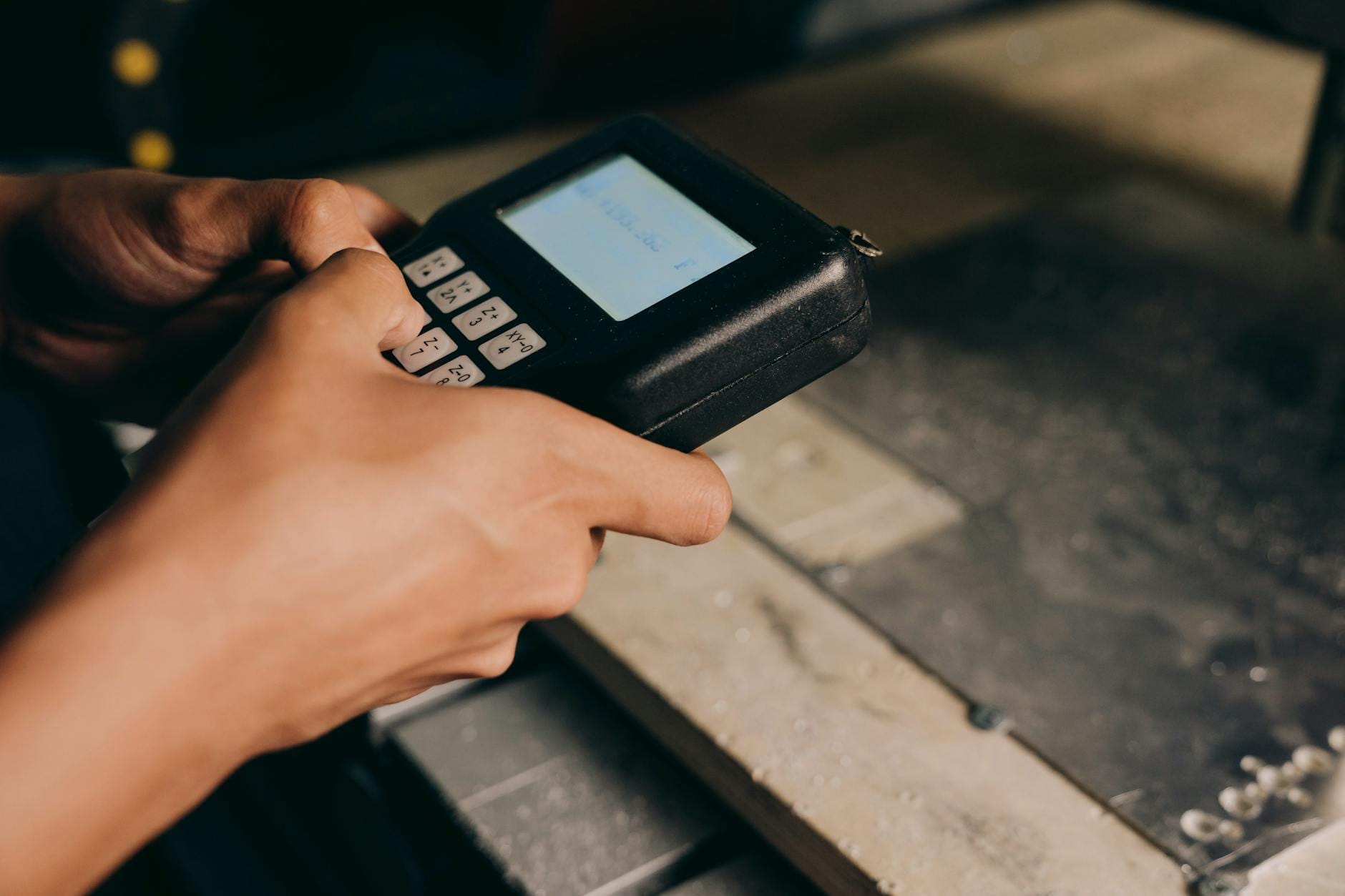 Zbliżenie dłoni obsługujących nowoczesne elektroniczne urządzenie sterujące